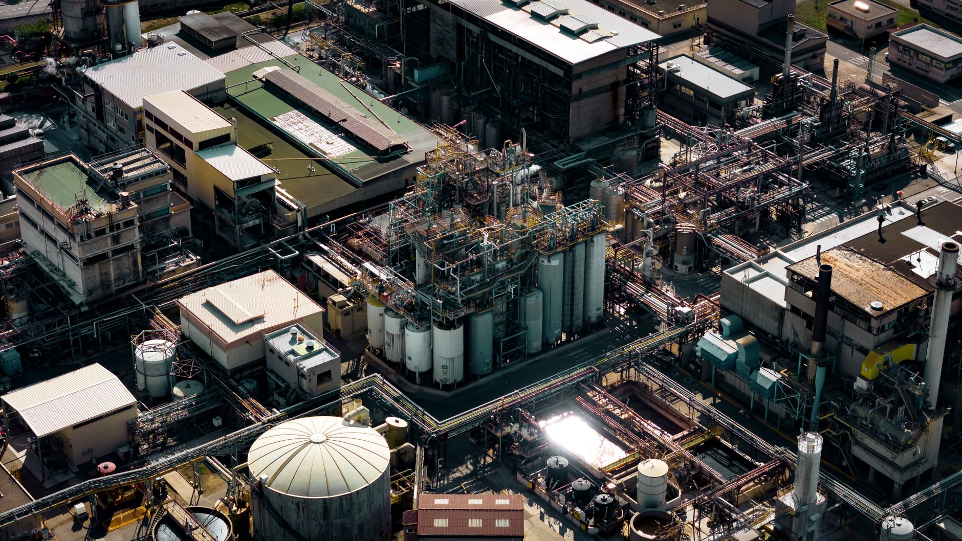 Aerial shot of a bustling industrial area in Marseille, France, showcasing silos and pipes.