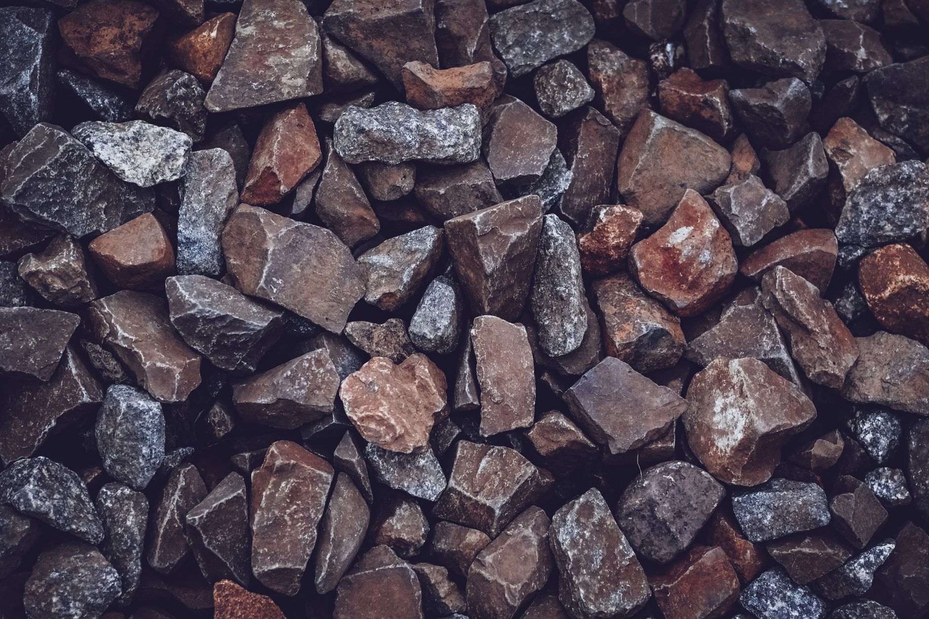 A detailed close-up of various rough brown and grey stones, displaying texture and natural patterns.