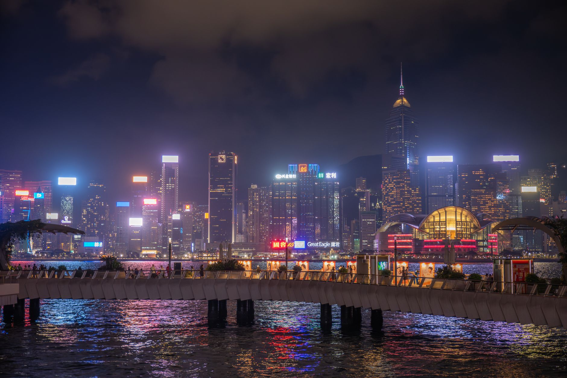 Night view of Kowloon's vibrant cityscape with illuminated skyscrapers and neon lights.