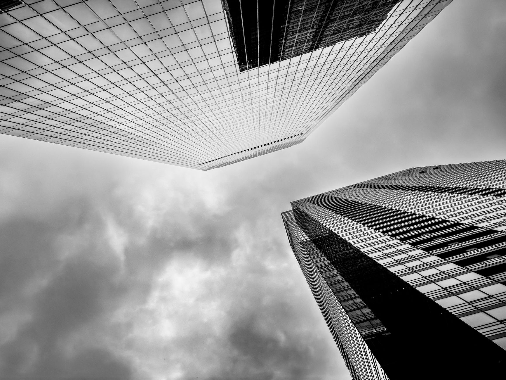A striking black and white photo of Chicago skyscrapers under a cloudy sky, showcasing modern architecture.