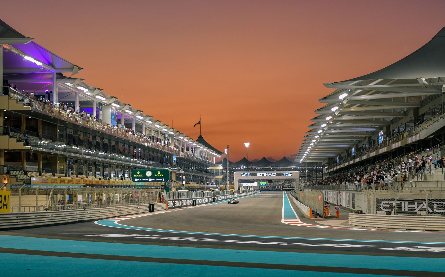 Formula 1 race event at Yas Marina Circuit, Abu Dhabi during sunset.